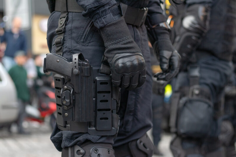 Close-up view to armed police officer with gun