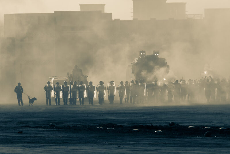 Military police riot response to a protest with tear gas smoke fire explosions Political expression riot protest demostration and military concept