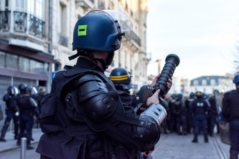 Gendarme avec lanceur de grenades lacrymogènes