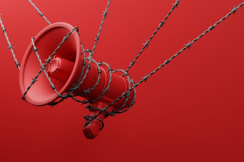 Red Megaphone with black wiggle barbed wire 3D rendering Protest against dictatorship threaten censored press concept poster and social banner horizontal design background with copy space